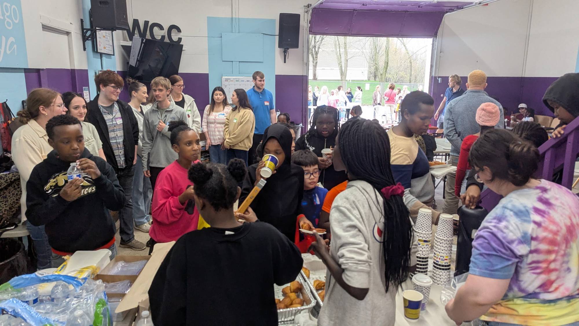 A room of people waiting in line to be served food from a buffet line